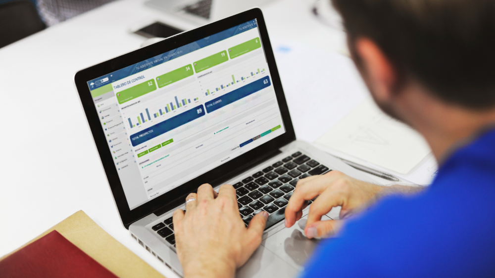 Agente de seguros usando su laptop con el dashboard de CRM para dar seguimiento a renovaciones y evitar pérdidas de clientes