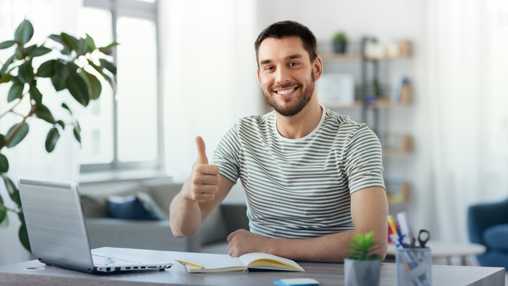 Agente de seguros sonriendo y levantando el pulgar al revisar su operación diaria en pocos minutos con apoyo de CRM