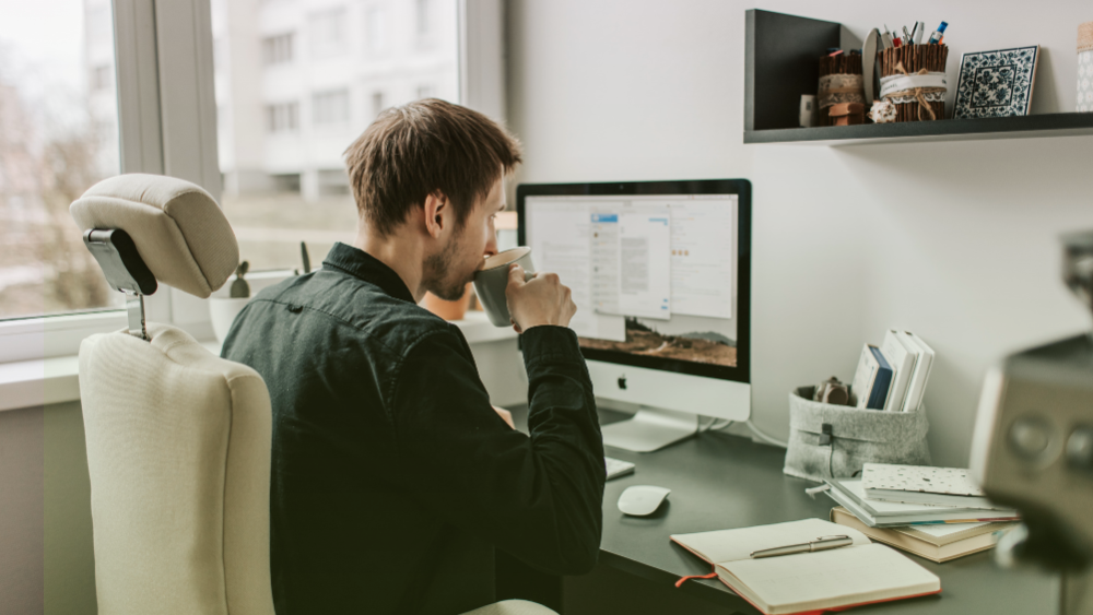 Agente de seguros trabajando con laptop y café automatizando su operación para mantener seguimiento constante